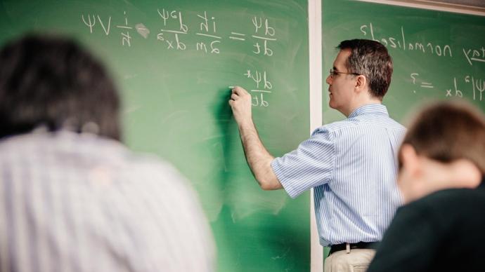 Dennis Ugolini writing formulas on chalk board