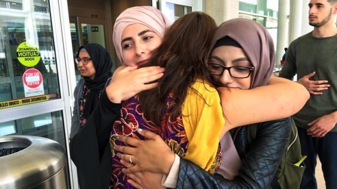 Students hug at airport