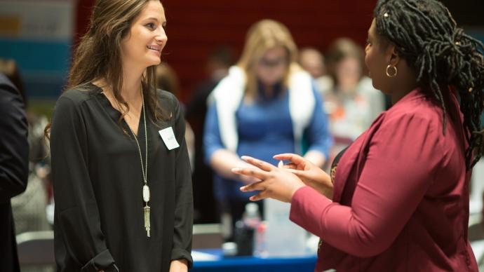 Sarah Thorne talking with a student at a career fair 