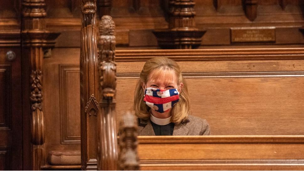 Jan Naylor Cope sits in a pew with a mask over her face