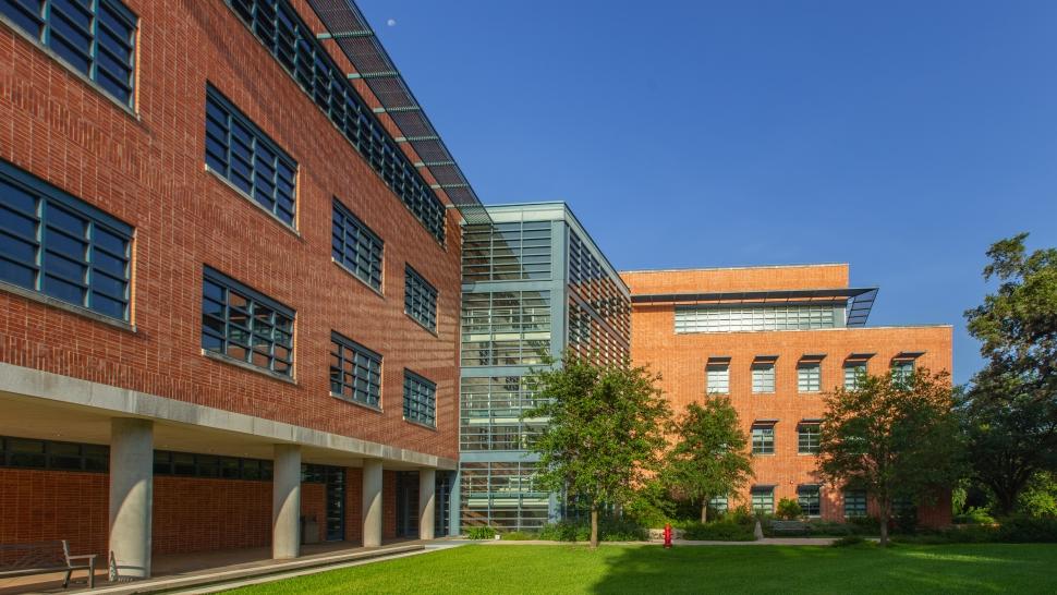 Exterior of Northrup Hall, featuring red brick, large glass windows, and trees