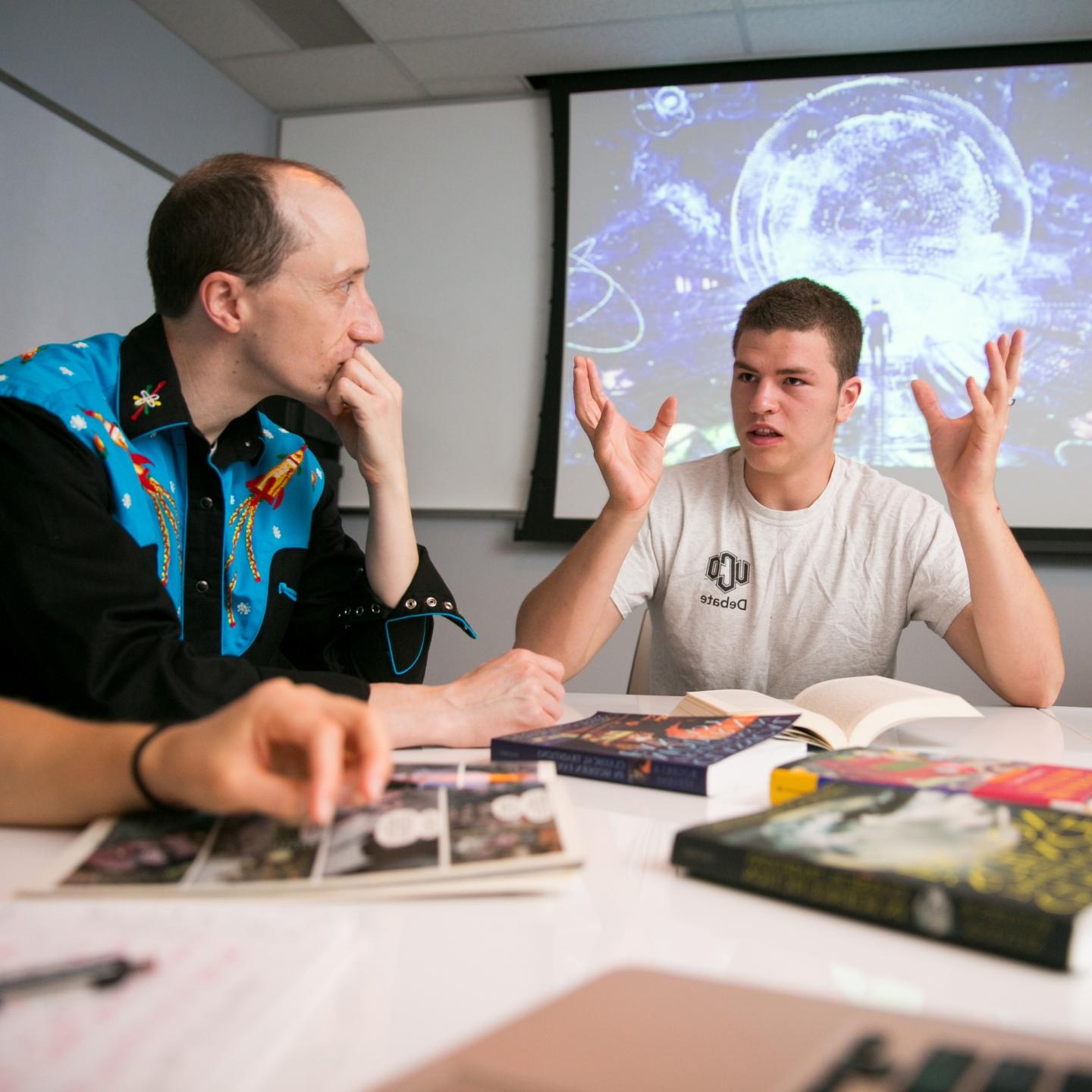 在实验室里，以赛亚·米切尔与本·史蒂文斯教授讨论科幻书籍