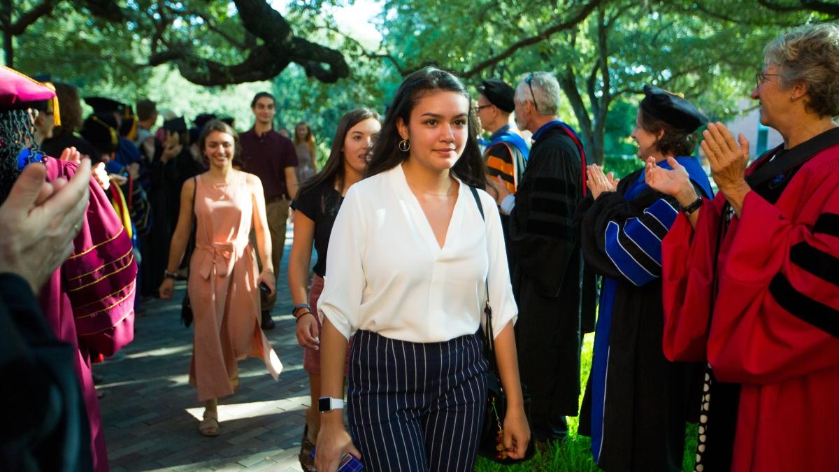 Female student walks along a path during new student convocation.