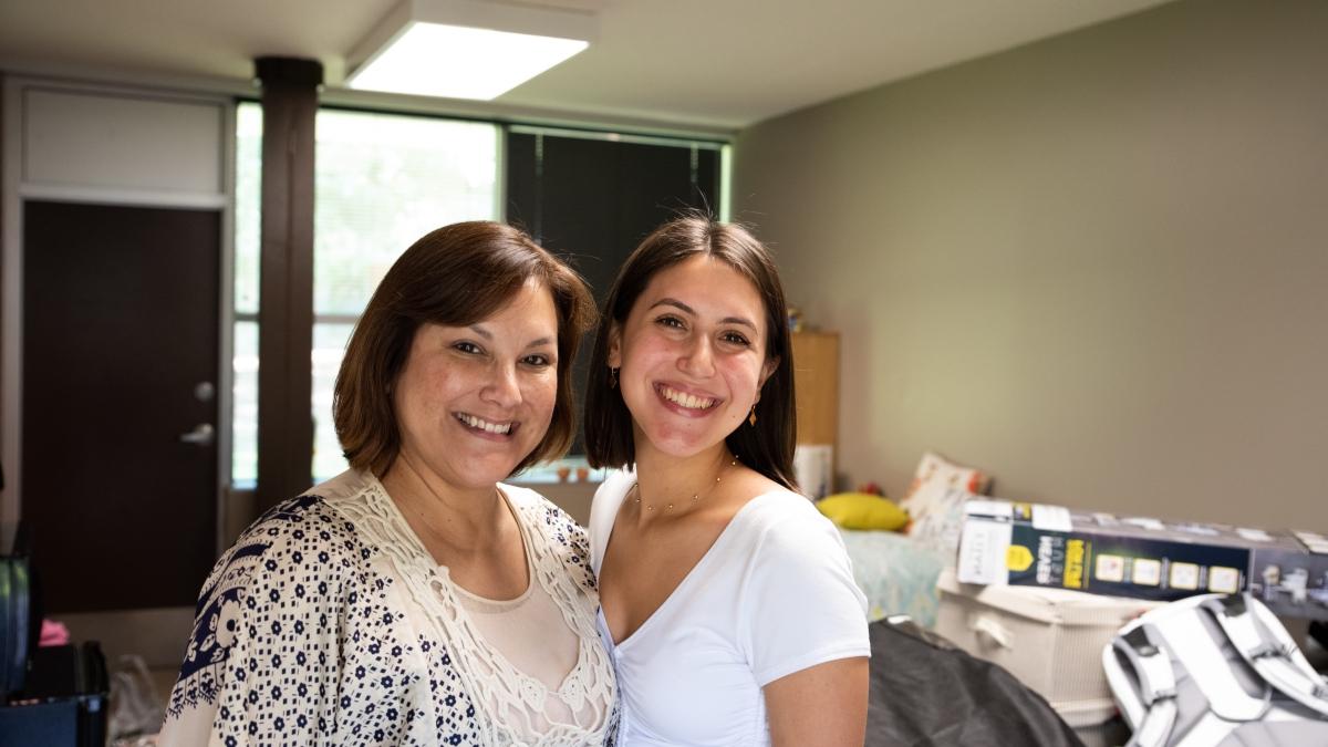 Mom and daughter standing in newly moved in dorm room