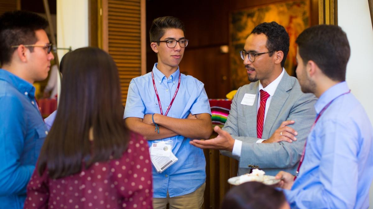 Professor talking to students at a reception
